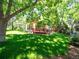 Lush backyard featuring a wooden deck, mature trees, and a well-manicured lawn at 15395 E Penwood Pl, Aurora, CO 80015