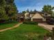 Charming home featuring a manicured lawn, mature trees, and an attached two car garage at 15395 E Penwood Pl, Aurora, CO 80015