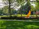 Outdoor community playground with slides and swings on a lush lawn surrounded by mature trees at 15395 E Penwood Pl, Aurora, CO 80015