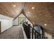 A loft area with a wood ceiling, carpeted floor, and doors that lead to a private balcony at 46 Silver Creek Rd, Idaho Springs, CO 80452