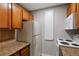 Galley kitchen featuring granite countertops, white appliances, and wood cabinets at 5995 E Iliff-1 Ave # 309, Denver, CO 80222