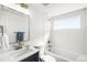 All-white bathroom featuring modern fixtures, including a navy vanity and a tiled shower-over-tub at 4210 S Dale Ct, Englewood, CO 80110