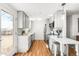 Modern kitchen with stainless steel appliances, white cabinets, and convenient breakfast bar at 4210 S Dale Ct, Englewood, CO 80110