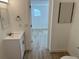 Bathroom features a vanity and sink with wood look tile flooring that leads into the next room at 805 Park Ave, Fort Lupton, CO 80621