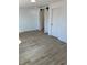 Bedroom with light walls, wood look tile flooring, and access to closet via sliding barn doors at 805 Park Ave, Fort Lupton, CO 80621