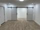 Bedroom with wood look tile flooring, light walls, and sliding barn doors to closet at 805 Park Ave, Fort Lupton, CO 80621