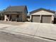 Tan home with a covered porch and a detached two car garage at 805 Park Ave, Fort Lupton, CO 80621