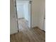 A hallway with wood-look flooring, opening into an adjacent room at 805 Park Ave, Fort Lupton, CO 80621