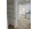 Hallway with wood look tile flooring, access to kitchen, and shelving at 805 Park Ave, Fort Lupton, CO 80621