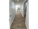 Hallway featuring wood look tile flooring, light walls, and access to kitchen at 805 Park Ave, Fort Lupton, CO 80621