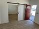 Bright living room with wood look tile flooring and a white barn door at 805 Park Ave, Fort Lupton, CO 80621