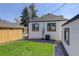 Cozy backyard with green grass, stone landscaping, and privacy fence with the back of the home at 141 S Knox Ct, Denver, CO 80219