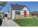 Charming exterior with a red front door, complemented by a well-maintained lawn and detached garage at 141 S Knox Ct, Denver, CO 80219