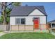 Lovely home with a bright red front door and wooden porch railing, set against a blue sky at 141 S Knox Ct, Denver, CO 80219