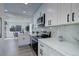 Modern kitchen with white cabinets, quartz countertops, and stainless steel appliances at 141 S Knox Ct, Denver, CO 80219