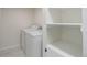Bright laundry area featuring new white washer and dryer, complemented by ample shelved storage at 141 S Knox Ct, Denver, CO 80219