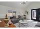Bright living room featuring a gray couch near a black front door with views to a quaint backyard at 141 S Knox Ct, Denver, CO 80219