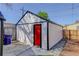 View of shed in backyard with red door and white siding at 141 S Knox Ct, Denver, CO 80219