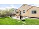 Backyard patio with modern furniture, lush green grass, and mature trees at 2140 Santa Fe Dr, Longmont, CO 80504