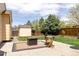 Backyard patio with modern furniture, lush green grass, shed, and mature trees at 2140 Santa Fe Dr, Longmont, CO 80504