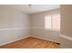 Empty bedroom features a hardwood floor, white trim, and a window with plantation shutters at 2140 Santa Fe Dr, Longmont, CO 80504