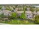 Aerial view of a fenced backyard featuring a well-maintained lawn, mature trees, and a glimpse of a neighborhood lake at 9272 Melborne Ct, Parker, CO 80134
