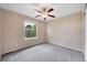 Empty bedroom with a ceiling fan, window, and neutral carpet at 9272 Melborne Ct, Parker, CO 80134