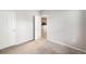 A carpeted bedroom features light gray walls, two doors, and an open doorway to an adjoining room at 3952 S Carson St # 103, Aurora, CO 80014