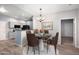 Eat-in dining area with a modern light fixture and views into the gray-toned kitchen with black appliances at 3952 S Carson St # 103, Aurora, CO 80014