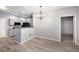 Dining area adjacent to the kitchen with hardwood floors, modern lighting, and a doorway to a carpeted room at 3952 S Carson St # 103, Aurora, CO 80014