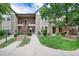 Inviting multi-level home featuring well-maintained landscaping, stone accents, and wooden stairways to upper units at 3952 S Carson St # 103, Aurora, CO 80014