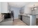 Cozy kitchen featuring gray cabinets, a breakfast bar, tile backsplash, and modern appliances at 3952 S Carson St # 103, Aurora, CO 80014