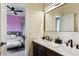 Bathroom featuring double sinks with a bedroom visible in the mirror's reflection at 598 Stonemont Dr, Castle Pines, CO 80108