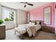 Bright bedroom featuring a pink accent wall and two decorative mirrors at 598 Stonemont Dr, Castle Pines, CO 80108
