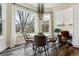 Cozy dining area with large windows, modern chandelier, hardwood floors, and desk area at 598 Stonemont Dr, Castle Pines, CO 80108
