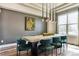 Modern dining room featuring a large table with stylish chairs and a unique pendant lighting fixture at 598 Stonemont Dr, Castle Pines, CO 80108