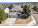 An aerial view of a large gray home with an attached three-car garage and beautiful stone accents at 598 Stonemont Dr, Castle Pines, CO 80108