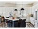Bright kitchen features white cabinets, marble backsplash, stainless steel appliances, and black pendant lighting at 598 Stonemont Dr, Castle Pines, CO 80108