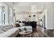 Open floor plan with living room and kitchen featuring hardwood floors, large windows, and a modern island at 598 Stonemont Dr, Castle Pines, CO 80108