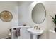 Chic powder room with pedestal sink, unique mirror, and decorative accents at 598 Stonemont Dr, Castle Pines, CO 80108