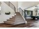 Elegant staircase with black metal railings and carpeted steps leading to a bright, open living space at 598 Stonemont Dr, Castle Pines, CO 80108
