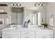 Bright bathroom featuring a double sink vanity, a large mirror, modern lighting, and a glass-enclosed shower at 9490 W 14Th Ave # 3, Lakewood, CO 80215