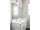 Bright bathroom featuring a double sink vanity, a large mirror, modern lighting, and a window at 9490 W 14Th Ave # 3, Lakewood, CO 80215