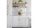 Kitchen details, showing floating shelves, white cabinets, decor, gray counters and subway tile backsplash at 9490 W 14Th Ave # 3, Lakewood, CO 80215