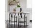 Close-up view of kitchen island featuring gray countertop and seating for two; floating shelves in background at 9490 W 14Th Ave # 3, Lakewood, CO 80215