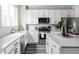 Well-lit kitchen featuring white cabinets, stainless steel appliances, light countertops, and modern fixtures at 9490 W 14Th Ave # 3, Lakewood, CO 80215