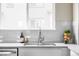 Bright kitchen showcasing stainless steel sink with modern faucet, white cabinets, and stylish decor at 9490 W 14Th Ave # 3, Lakewood, CO 80215