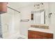 Bathroom with a shower/tub combination, wood vanity, mosaic backsplash, and modern bronze fixtures at 2972 Kearney St, Denver, CO 80207