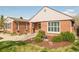 Inviting brick home showcasing a manicured lawn, beautiful landscaping, and a cozy front patio at 2972 Kearney St, Denver, CO 80207