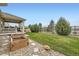 Serene backyard features a covered patio, landscaped garden, and spacious grass area at 15211 Quince St, Thornton, CO 80602